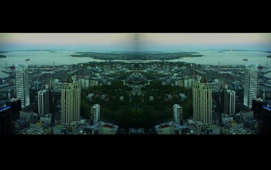A view of a city taken from high up has been mirrored to reflect itself